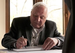 portrait of Victor Hand signing a book